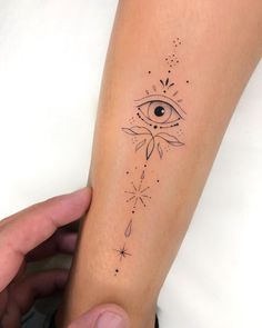 someone holding their arm with an eye tattoo on it