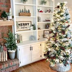 a decorated christmas tree sitting in front of a white book shelf filled with holiday decorations