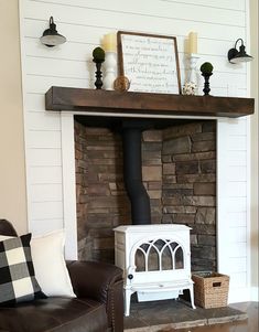 a living room with a fire place next to a brown leather chair and pillows on the floor