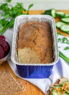 a loaf of bread sitting on top of a table next to some sliced up vegetables