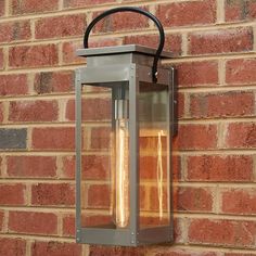 an outdoor light on the side of a brick wall