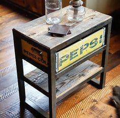 a small wooden table with an old pepsi sign sitting on it's side shelf