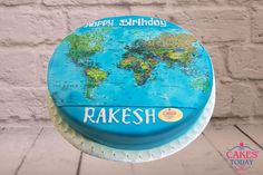 a birthday cake decorated with a map of the world and name rakesh on it