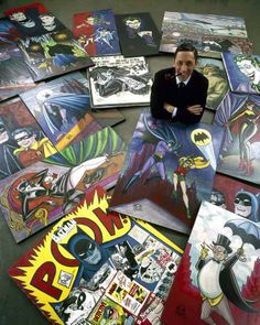 a man standing in front of a pile of comic book covers with batman characters on them