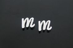 the letters m and m are written in white on black paper, with one letter missing