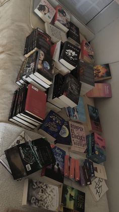 a pile of books sitting on top of a bed