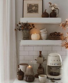 a kitchen counter with coffee maker, candles and other items on it's shelf