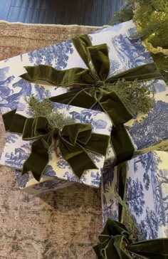 two wrapped presents with green bows on them