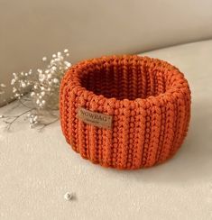 an orange knitted bowl sitting on top of a table