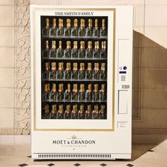 a vending machine with many bottles of champagne in it's display case, sitting on a tiled floor