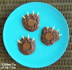 three cookies shaped like animals on a blue plate with toothpicks in the middle