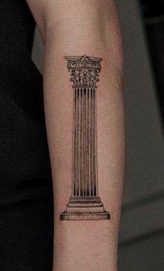 a woman's arm with a black and white photo of a pillar on it