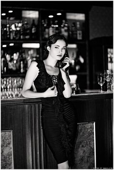 a woman sitting at a bar talking on a cell phone