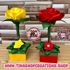 two paper roses are sitting in small boxes on a table with qr - code