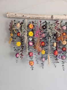 an arrangement of flowers hanging on a wall