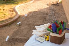 a bunch of colorful objects sitting on top of a white table cloth next to a building