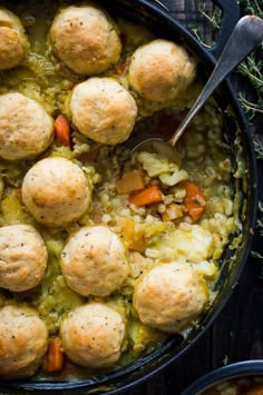 a pot filled with dumplings and vegetables on top of a wooden table