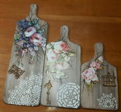 three wooden cutting boards decorated with flowers and birds