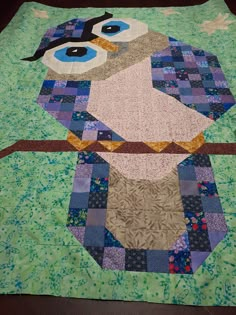 a quilted table runner with an owl on it