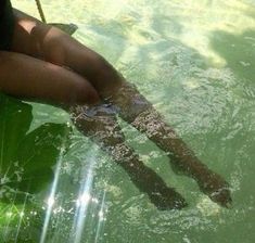 a woman is floating in the water with her legs up