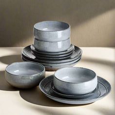 a stack of plates and bowls sitting on top of a table next to each other