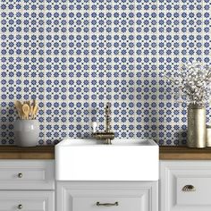 a white sink sitting under a blue and white wall