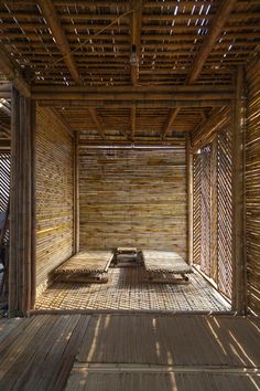 the inside of a bamboo hut with tables and benches