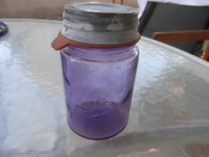 a purple mason jar sitting on top of a table