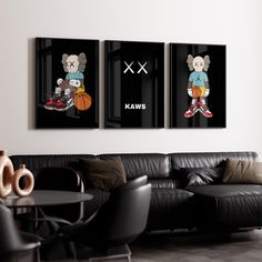 three cartoon characters are hanging on the wall above a black couch in a modern living room