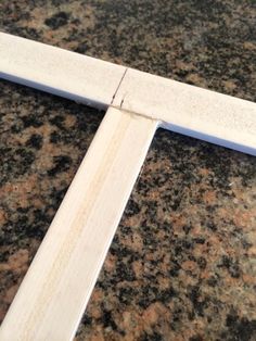 a close up of a wooden cross on a granite counter top with the end cut off