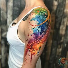 a woman's arm with colorful paint splattered on the arm and shoulder