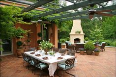 an outdoor dining area with patio furniture and table set for six, surrounded by greenery