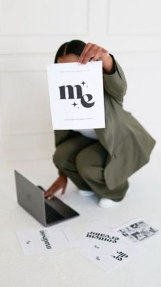 a person sitting on the floor holding up a sign over their face with both hands