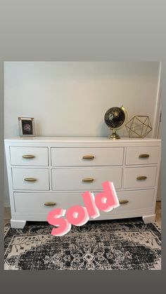 a white dresser sitting on top of a rug