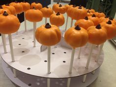 there are many orange pumpkins on sticks in the shape of lollipops