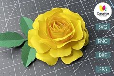 a yellow rose sitting on top of a cutting board next to scissors and paper flowers