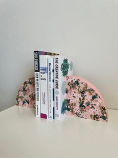 three books are stacked on top of each other in the shape of a half - moon