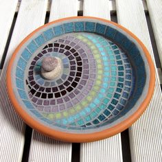 an orange and blue bowl sitting on top of a wooden table