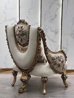 an ornately decorated chair sits in front of a marble paneled wall and floor