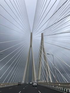 a car driving across a bridge on a cloudy day