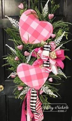 a pink and black heart wreath on the front door