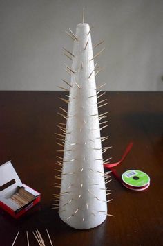 a white christmas tree sitting on top of a wooden table next to scissors and tape