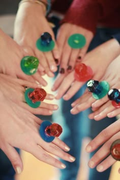 many different colored rings in the middle of each other with their hands holding them together