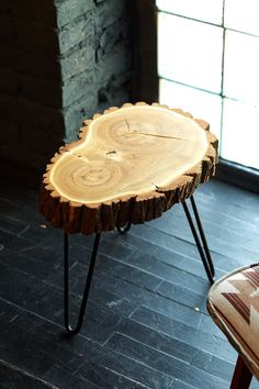 a wooden table sitting on top of a hard wood floor next to a window in a room