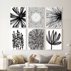 four black and white art prints hanging on the wall above a couch in a living room