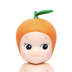 a small toy with an orange on it's head and eyes, sitting in front of a white background