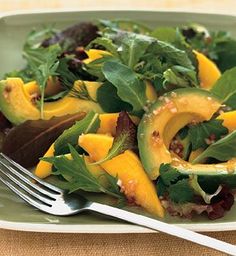 a salad with avocado and spinach is on a plate