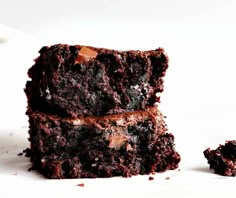 two chocolate brownies stacked on top of each other with one bite taken out of it