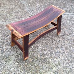 a wooden bench sitting on top of a cement floor next to a sidewalk with no people