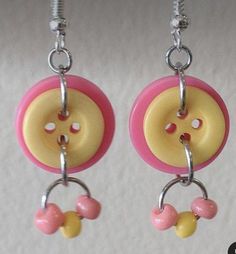 pair of pink and yellow button earrings hanging from hooks